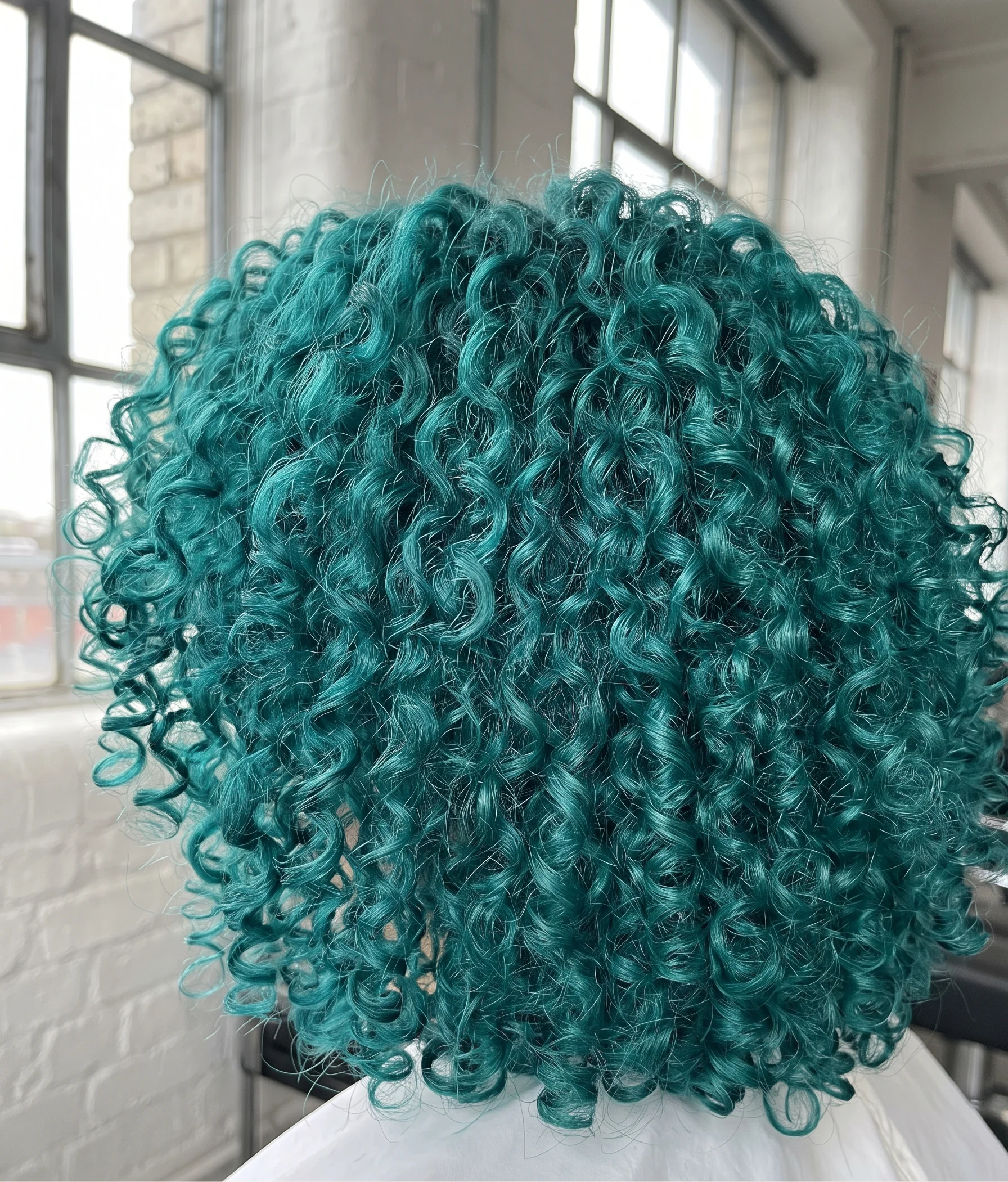 Vivid teal colour on defined 3B curls in flat daylight, each curl saturated and springy